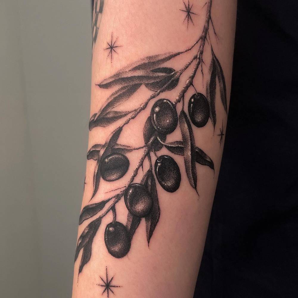Dotwork style olive branch tattoo located on the upper arm.