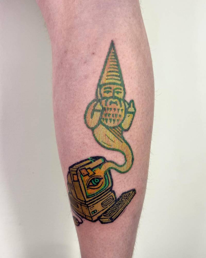 Pop art style computer and gnome tattoo located on the calf.