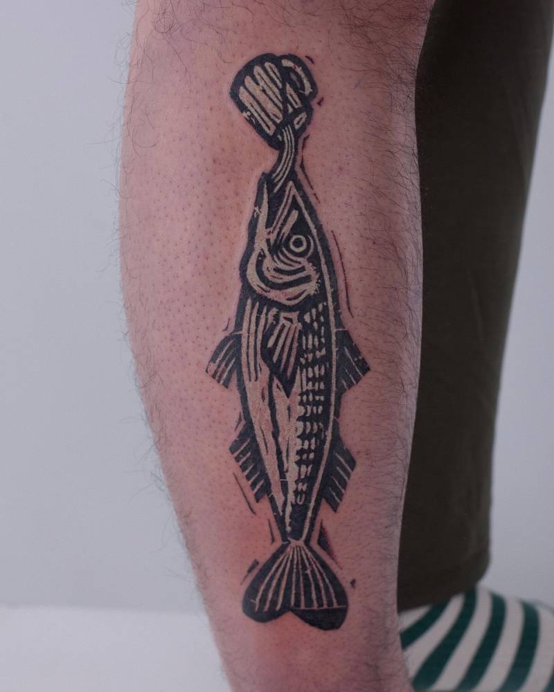 Beer drinking salmon tattoo located on the shin, blackwork style.