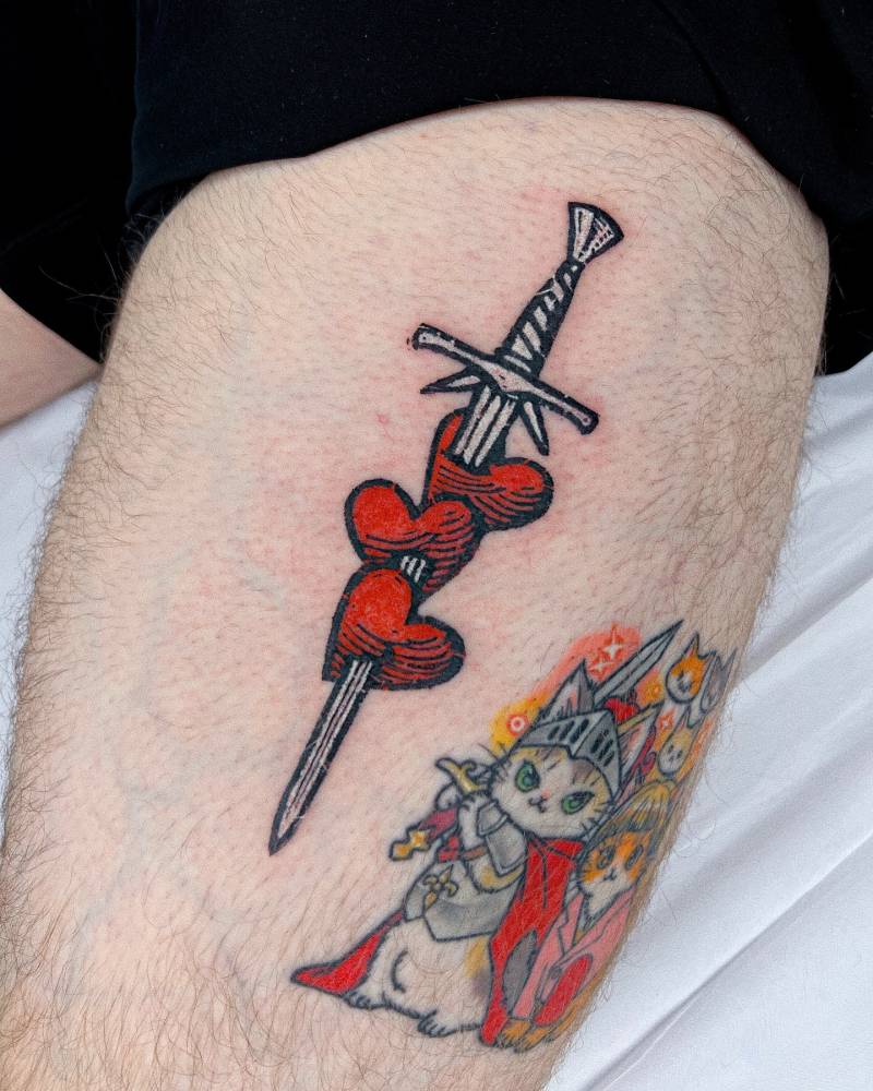 Pop art style sword and hearts tattoo done on the thigh.