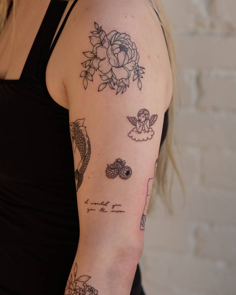 Upper arm composition tattoo in fine line style.