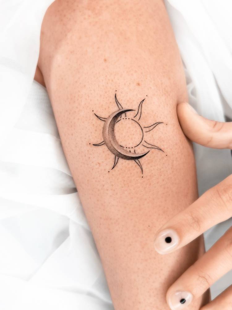 Sun and moon tattoo located on the inner forearm.