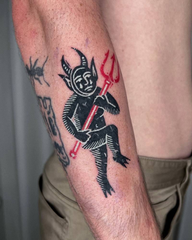 Pop art style devil tattoo placed on the forearm.
