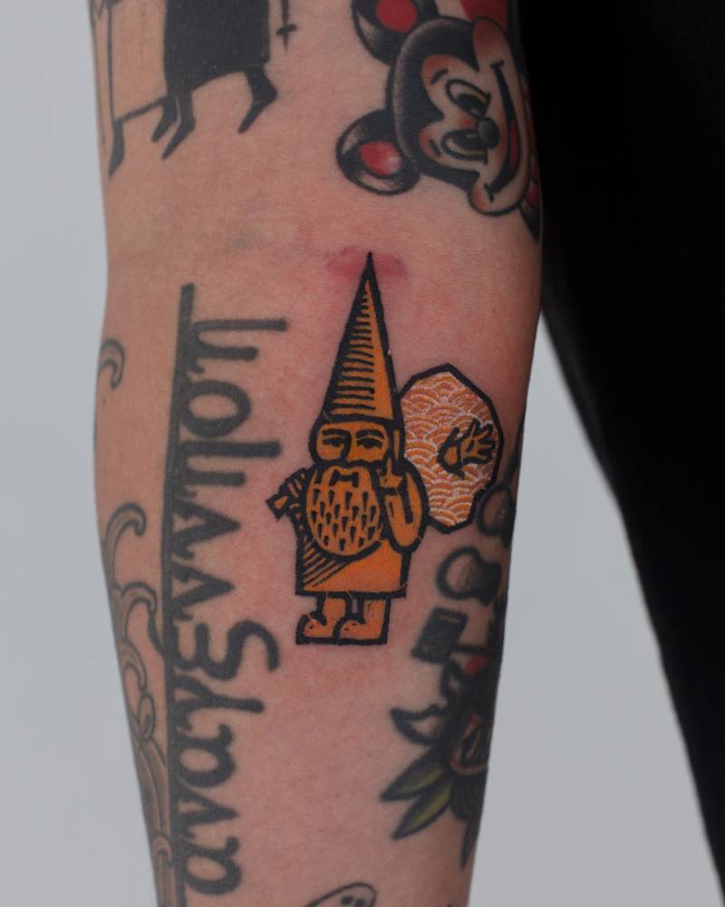 Gnome gap filler tattoo in pop art style done on the inner forearm.