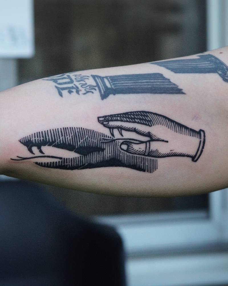 Hand and snake shadowgraphy tattoo located on the iner arm.