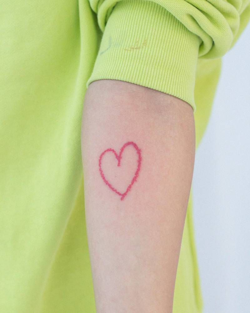 Red crayon heart tattoo located on the inner forearm.
