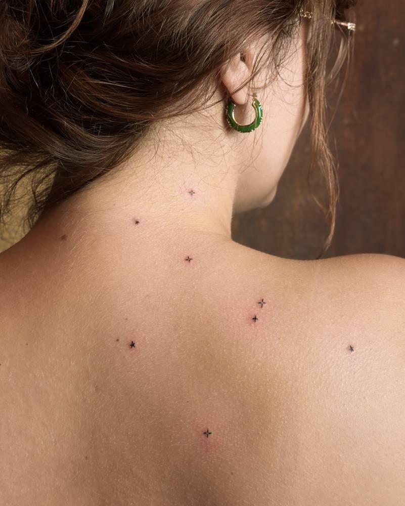 Minimalistic star collection tattooed on the shoulder blade.