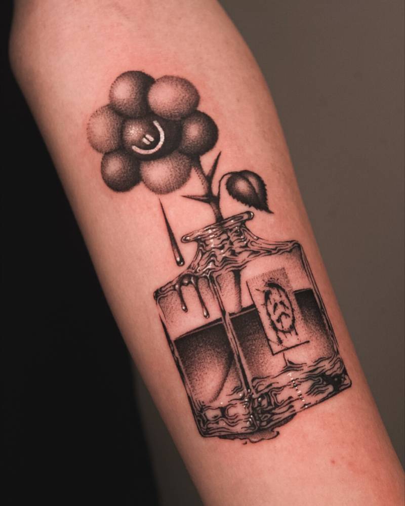 Flower in a bottle tattoo located on the inner forearm.
