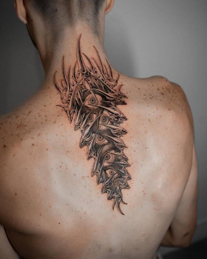 Thorns and eyes tattoo located on the upper back, done in illustrative style.