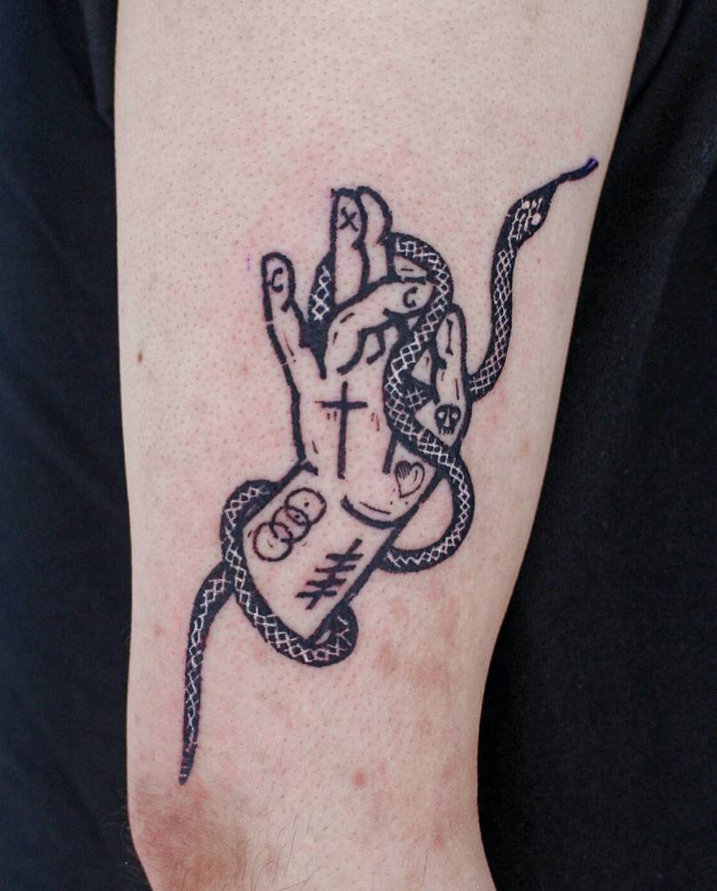 Hand and snake tattoo located on the upper arm.