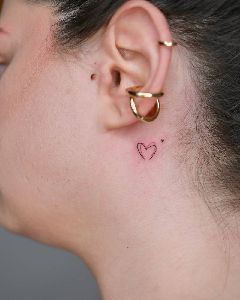 Tiny minimalistic hearts tattoo located behind the ear.