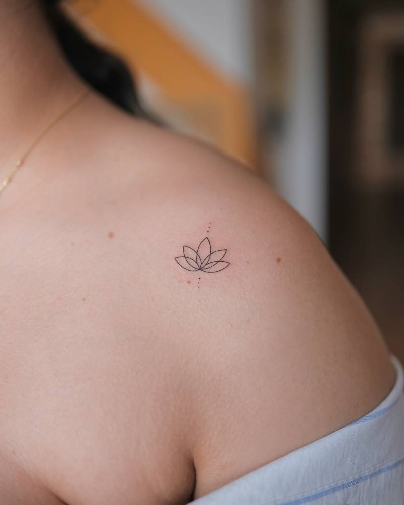 Little lotus flower tattoo done on the shoulder, fine line style.