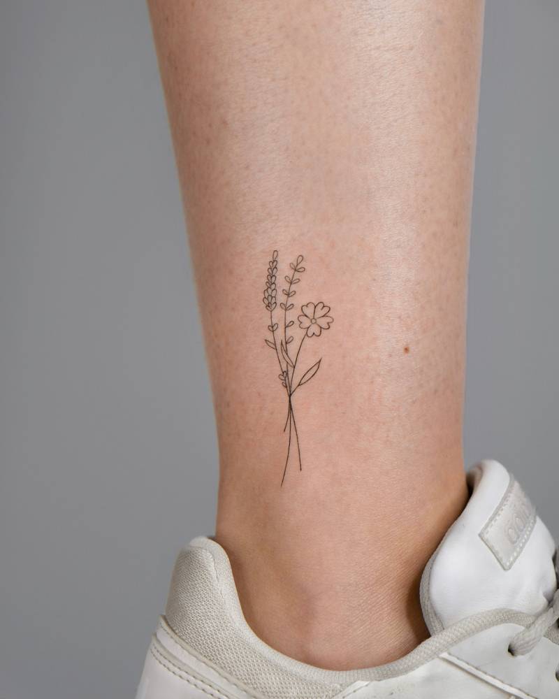 Flower bouquet tattoo located on the ankle, done in fine line style.
