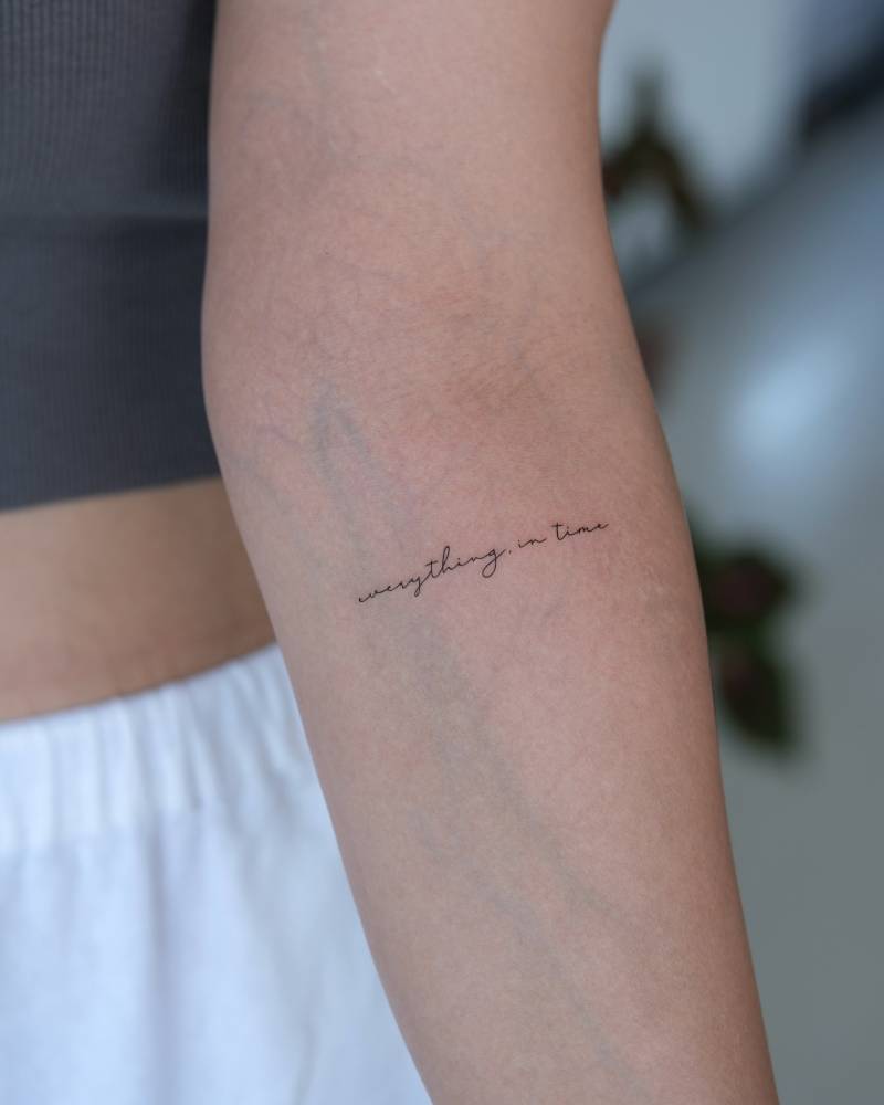 "Everything in time" lettering tattoo located on the inner forearm.