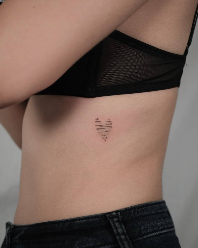 Scribble heart tattoo located on the rib.