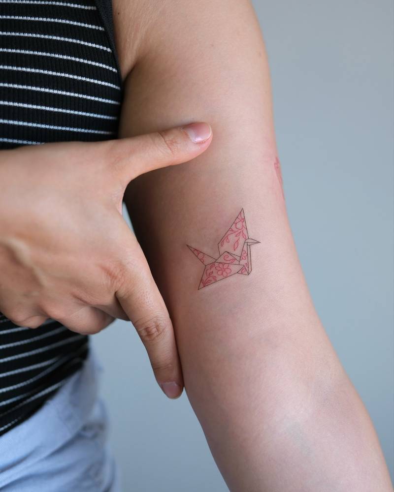Origami crane tattoo in fine line style done on the inner forearm.