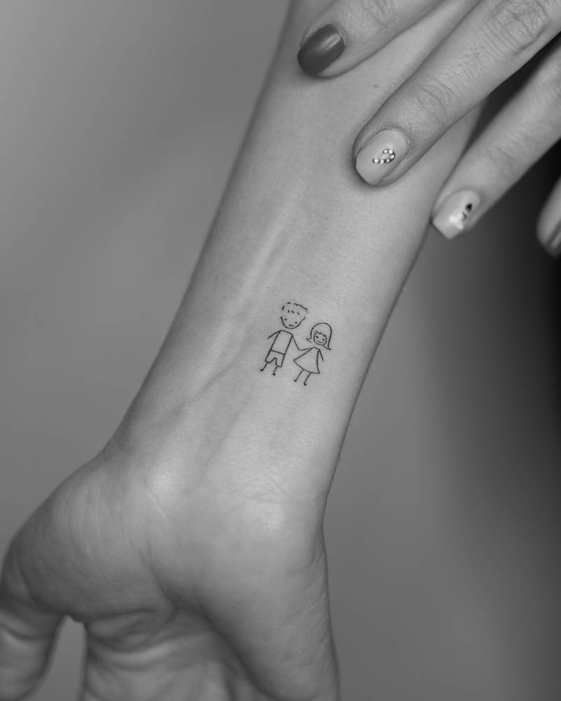 Minimalistic style little lovers tattoo located on the wrist.