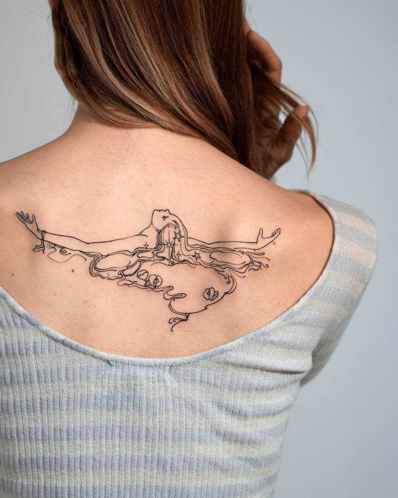 Sketch work style woman swimming tattooed on the upper back.