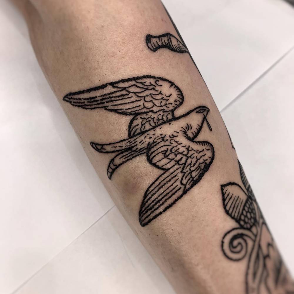 Engraving style dove tattoo located on the forearm.