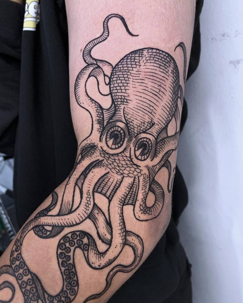 Octopus tattoo in engraving style located on the elbow.