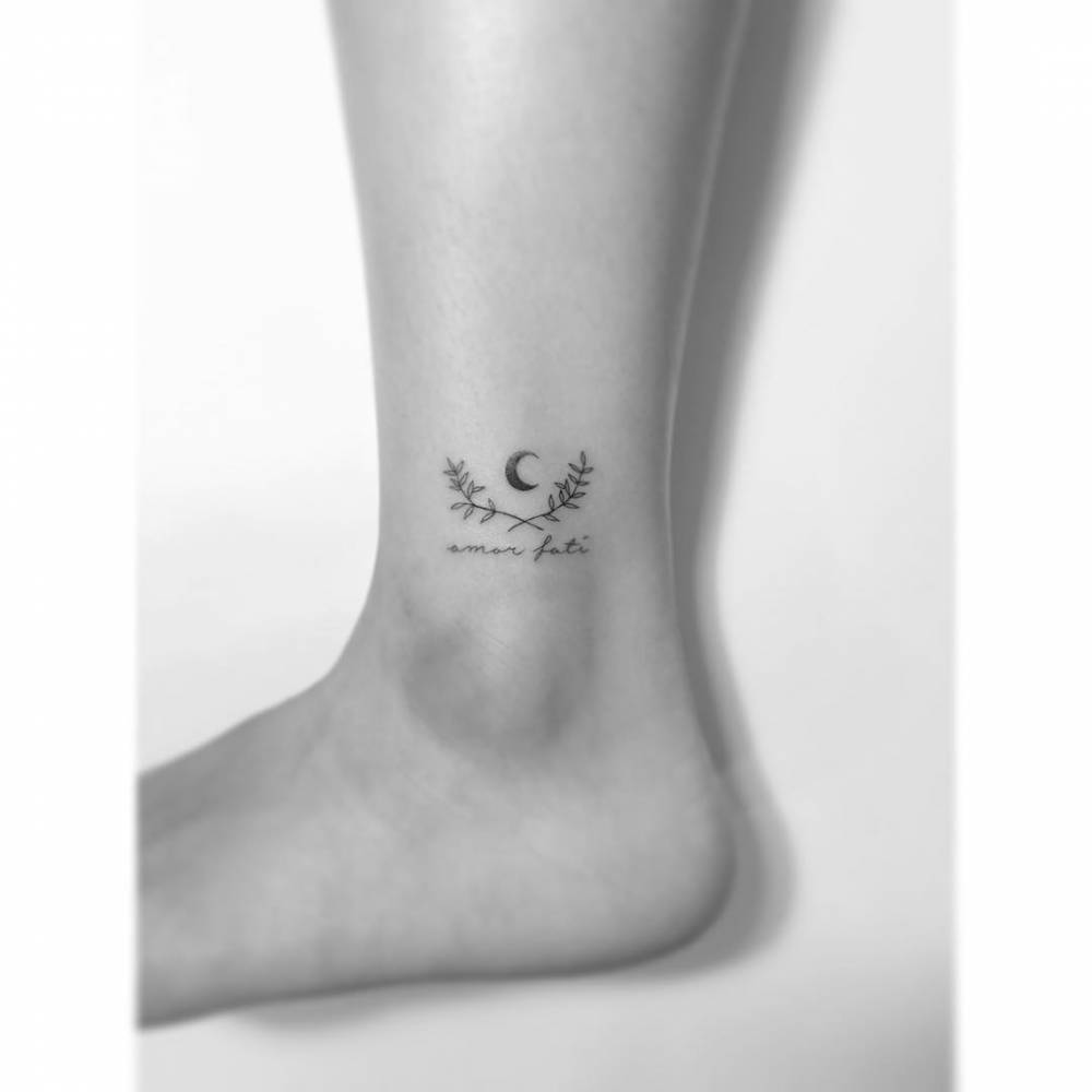 Laurel wreath and "amor fati" tattoo located on the ankle.