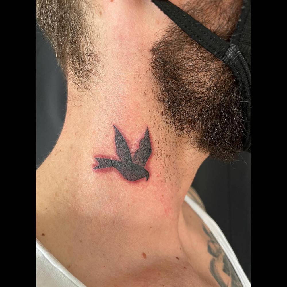Blackwork style swallow tattoo located on the neck.