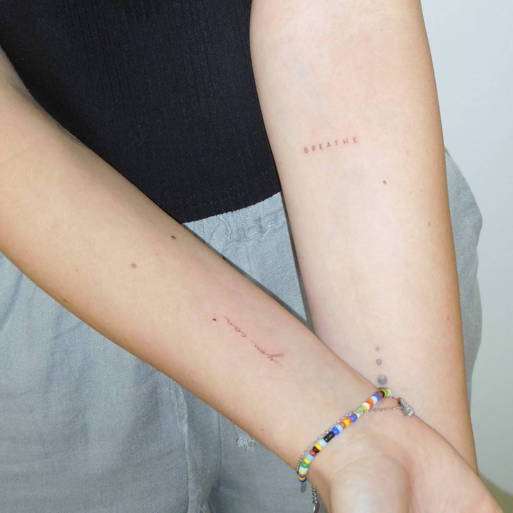 "You can" and word "breathe" lettering tattoos.