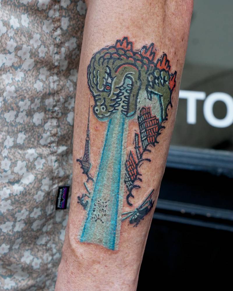 Godzilla tattoo on the left forearm.