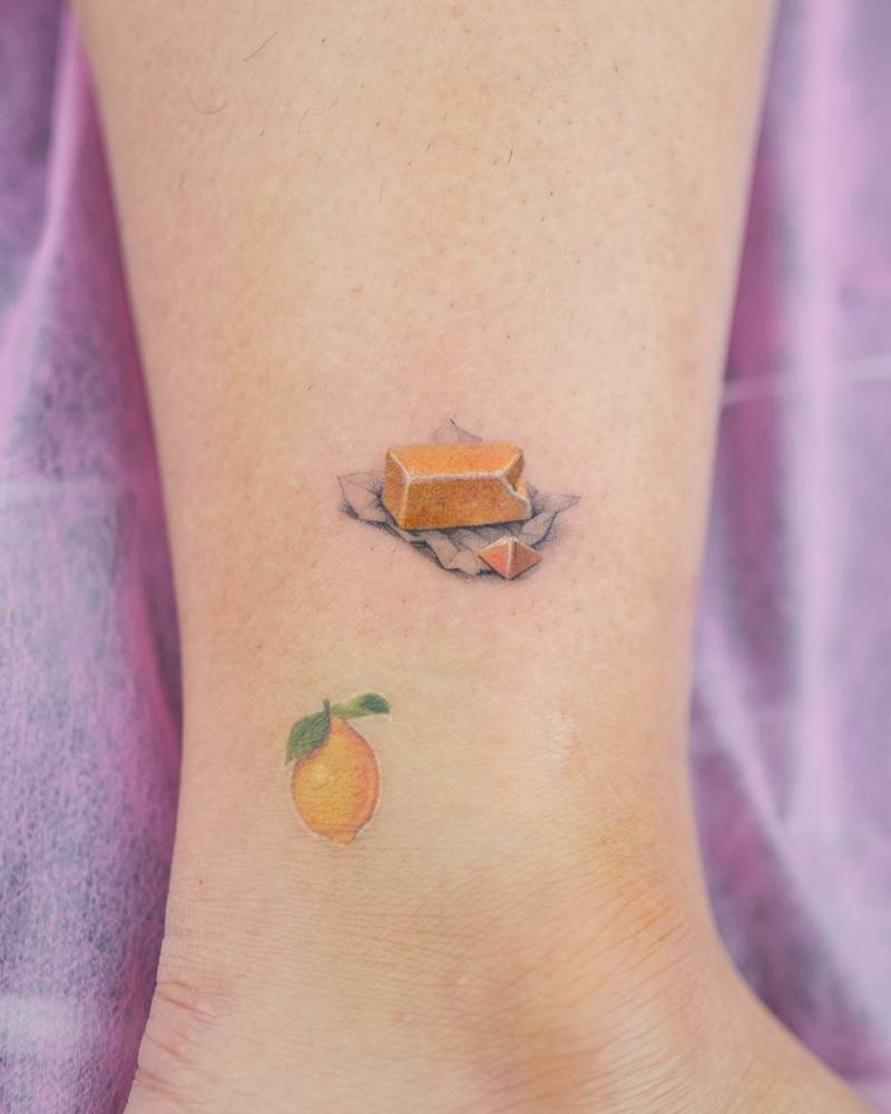 Butter and lemon tattoos in micro-realistic style located on the ankle.