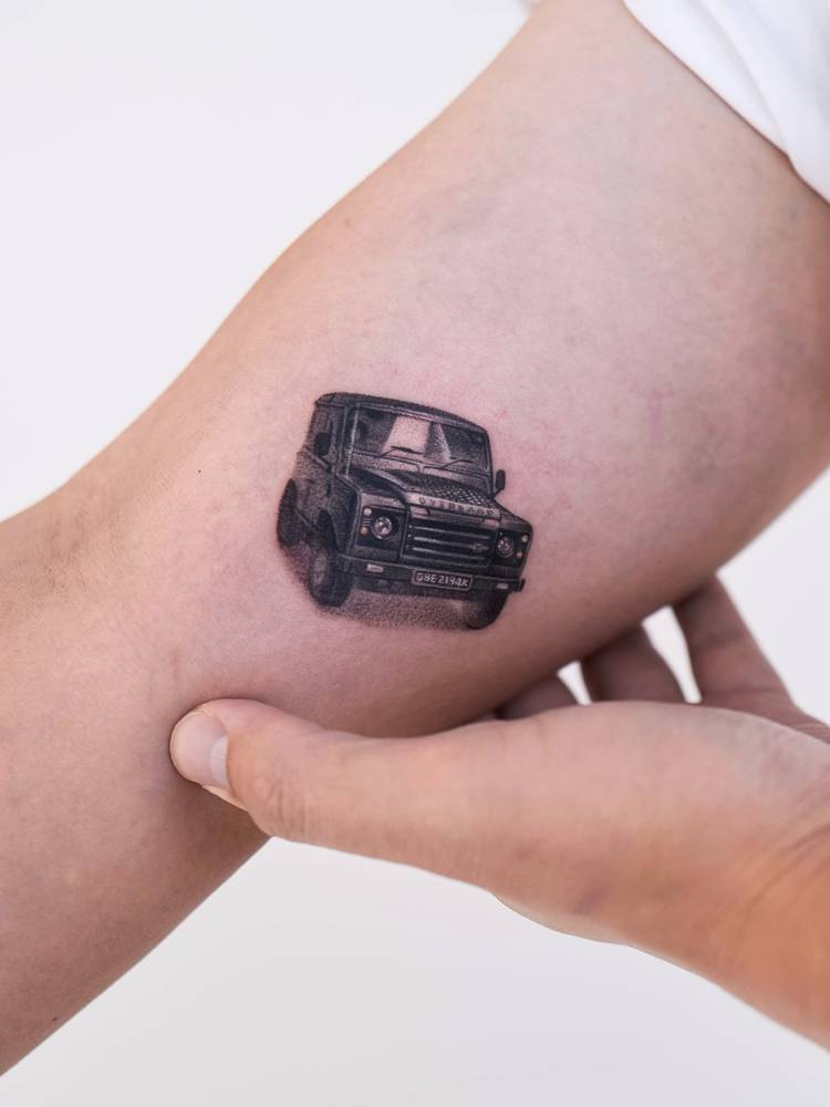 Micro-realistic style Land Rover tattoo located on the inner arm.