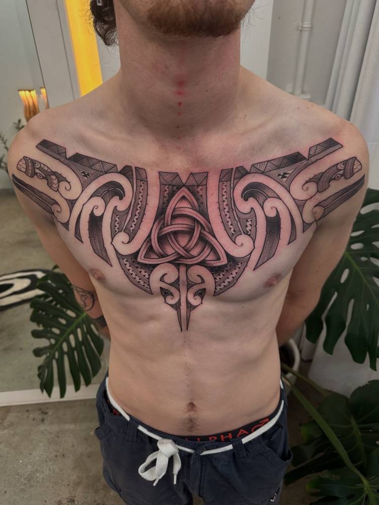 Celtic style trinity knot tattoo located on the chest.