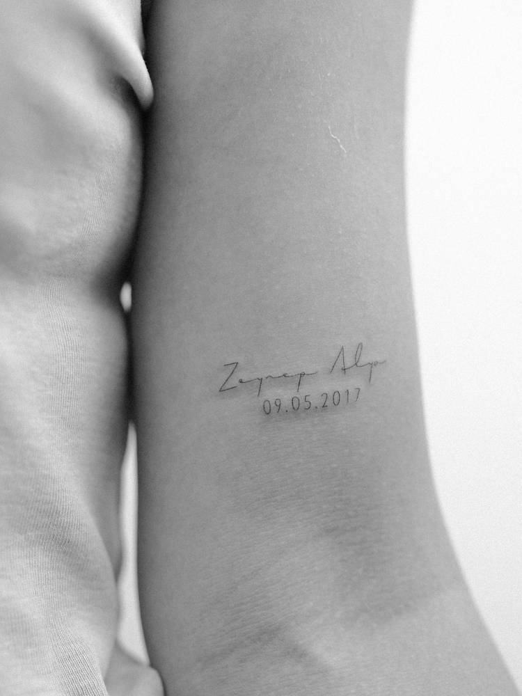 Name and date tattoo located on the bicep.