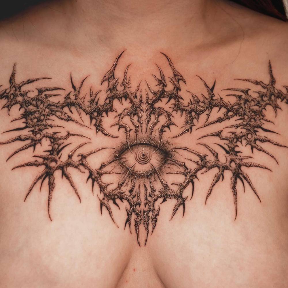 Illustrative style thorns and eye tattoo located on the chest.