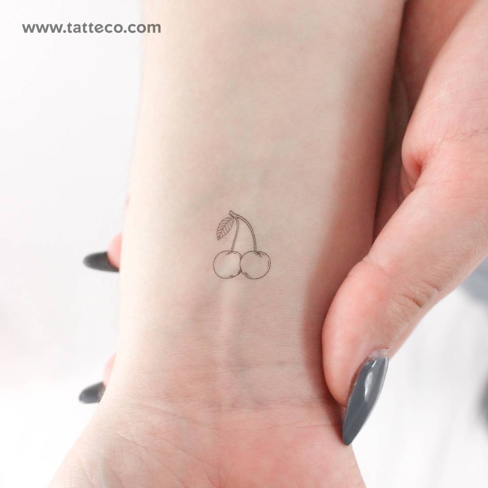 Fine line style little cherry couple temporary tattoo located on the wrist.