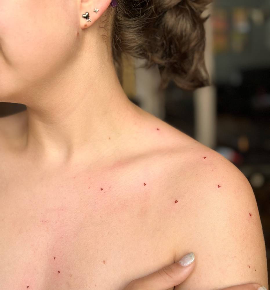 Freckle hearts tattoo located on the shoulder.