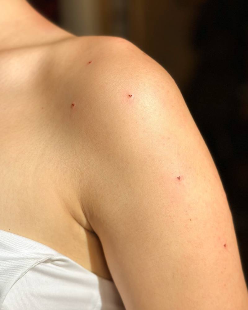 Freckle hearts tattoo located on the shoulder.