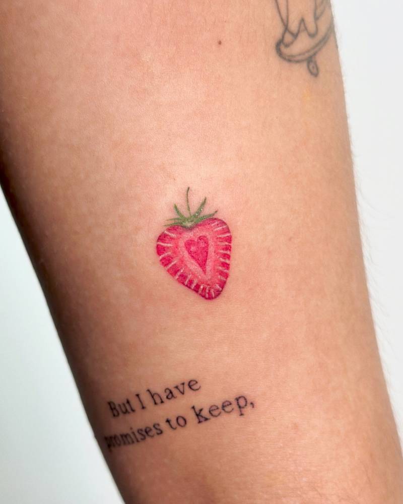 Watercolor style strawberry tattoo located on the inner arm.