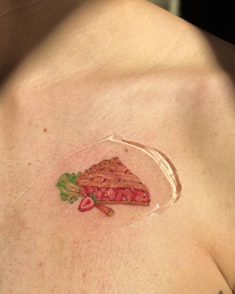 Illustrative style pie slice tattoo located on the chest.