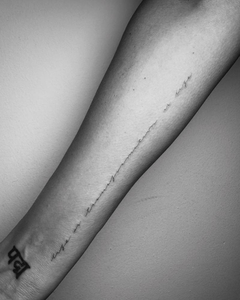 Lettering tattoo that says "life is transformation, transformation is life" located on Jessica Alba's inner forearm.