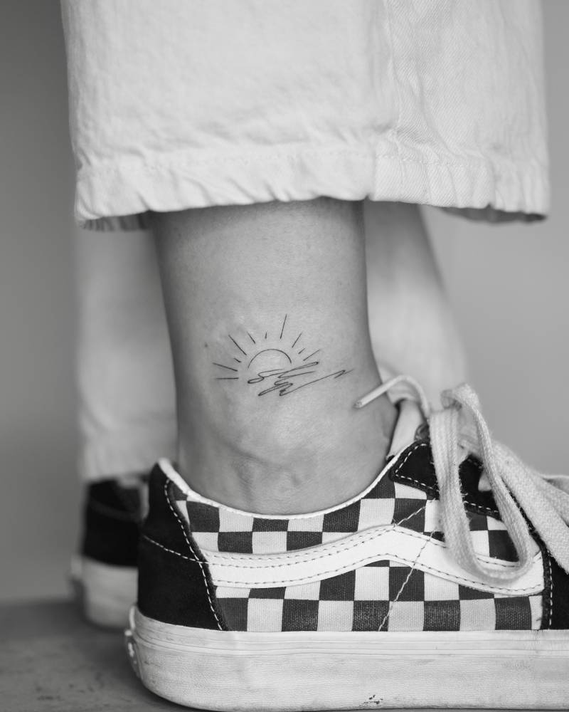 Abstract style sea sunset tattoo located on the ankle.