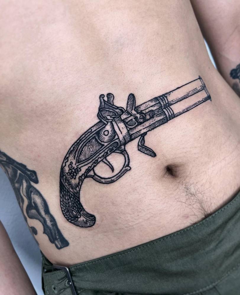 Blunderbuss tattoo in engraving style located on the stomach.