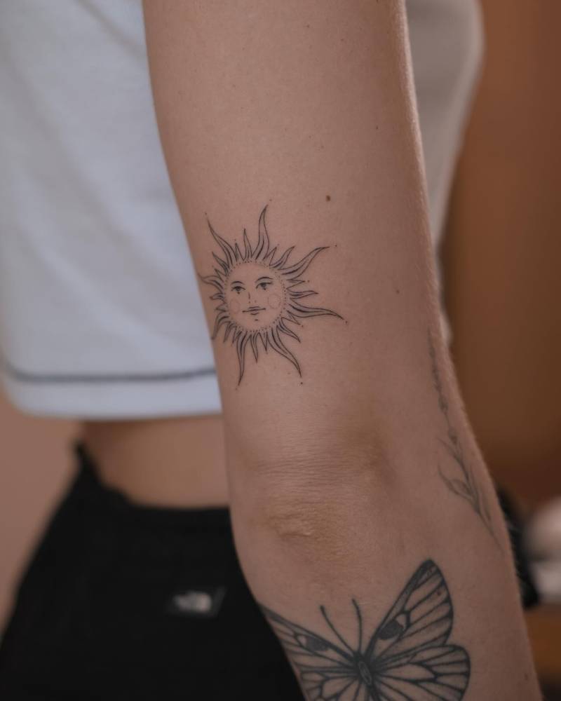 Inti sun tattoo located on the tricep, hand poked style.