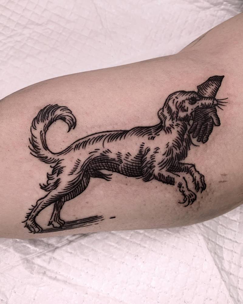Engraving style dog tattoo located on the inner arm.