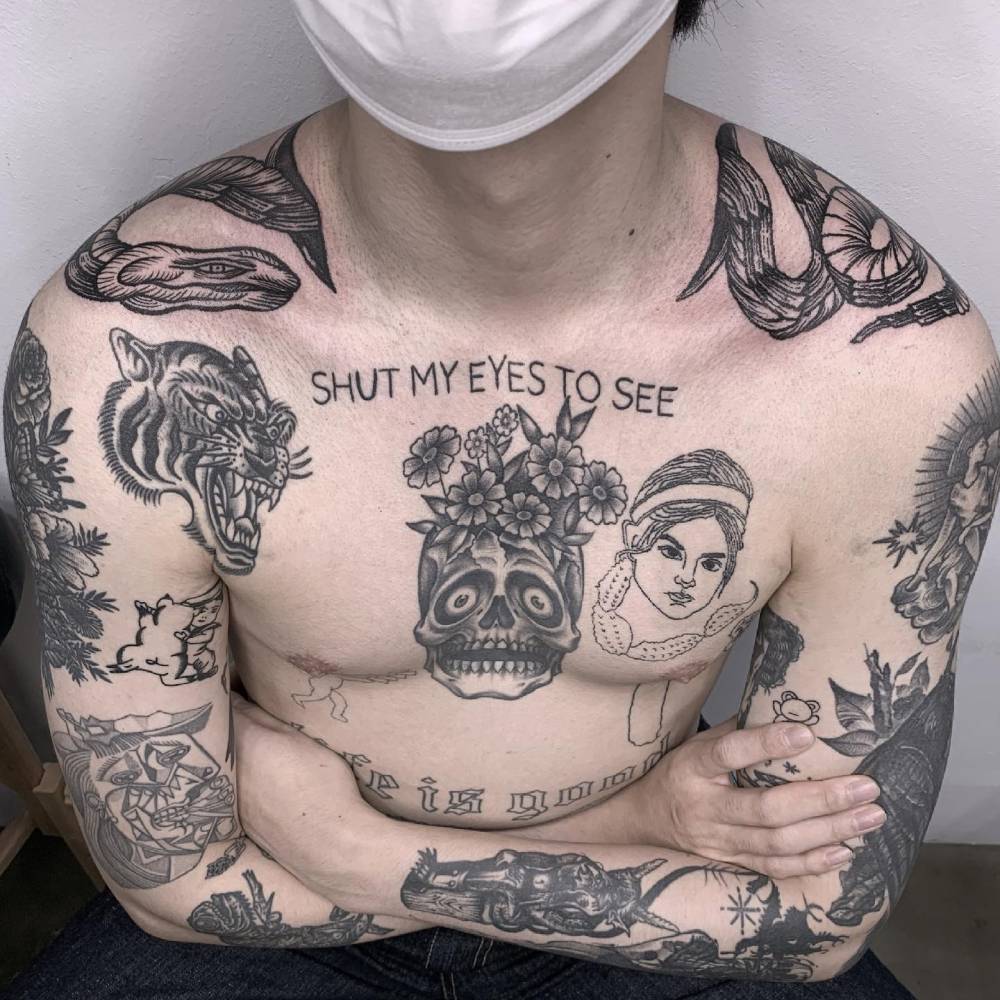 Engraving style snake tattoo located on the top of shoulders.