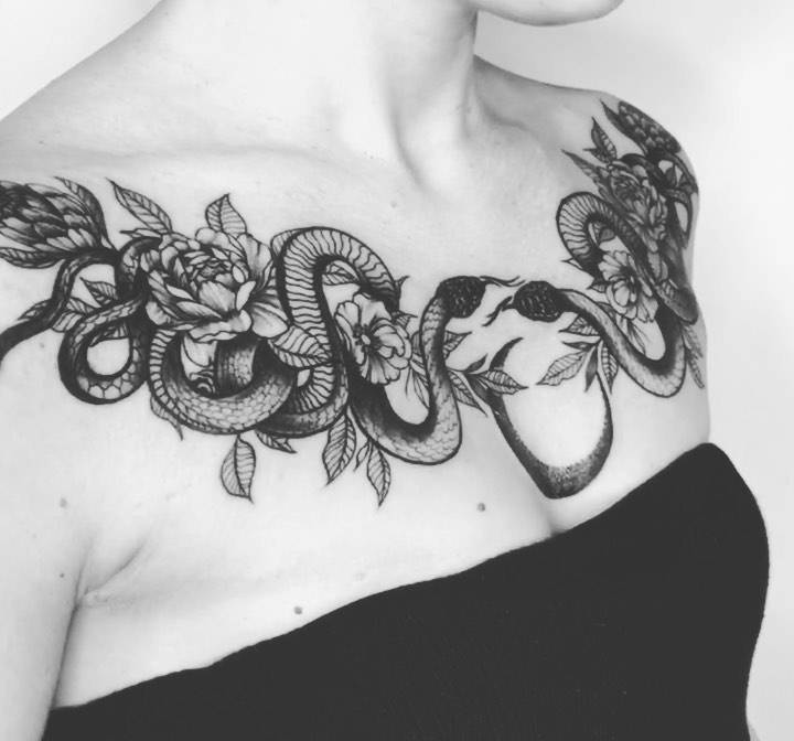 Blackwork snakes and peonies tattoo located on the chest.