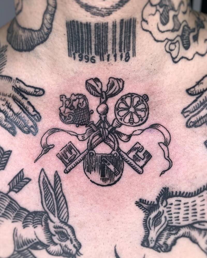 Keys and lock gap filler tattoo in engraving style, placed on the collarbone.