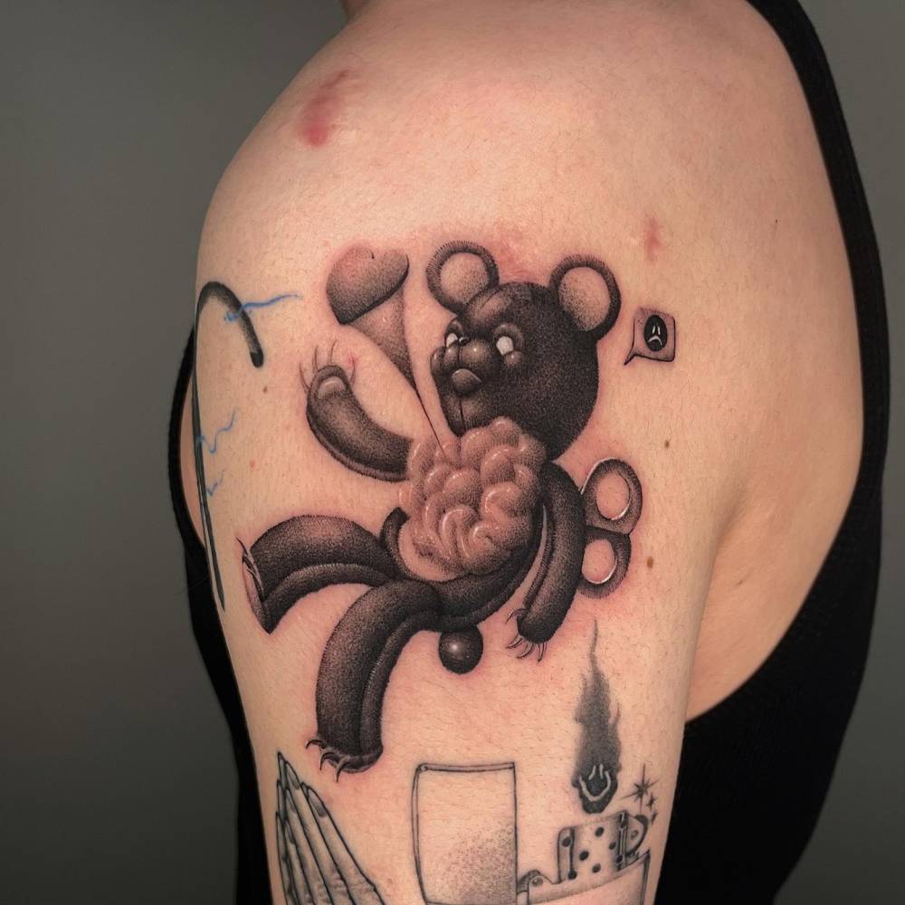 Dotwork style teddy bear tattoo located on the shoulder.