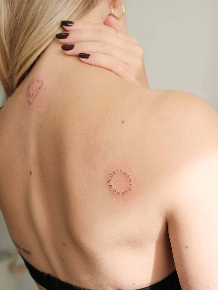 "More than you know" lettering tattoo located on the shoulder blade.
