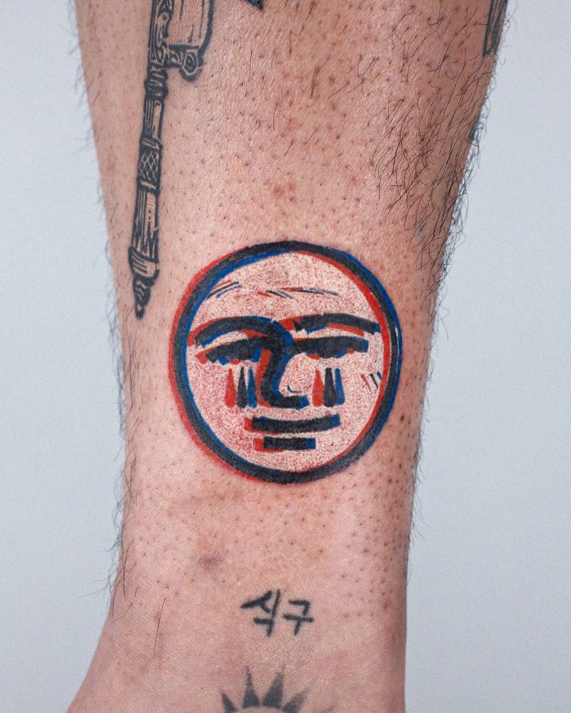 Anaglyph moon face tattoo in pop art style located on the ankle.
