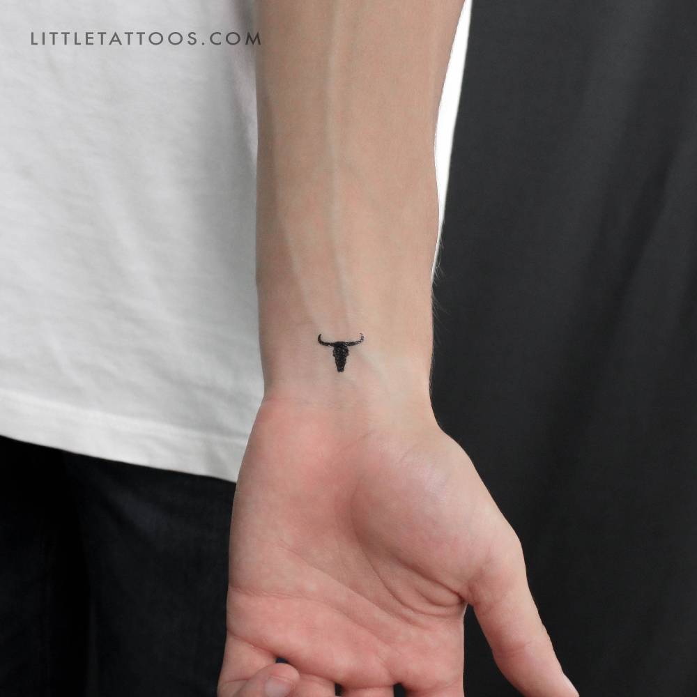Bull skull temporary tattoo in blackwork style located on the wrist.